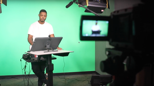 Man in recording studio with camera pointed at him