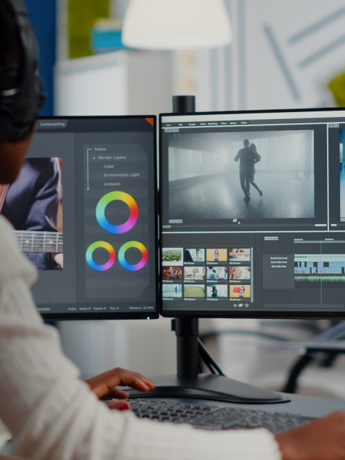 woman editing video using two monitors